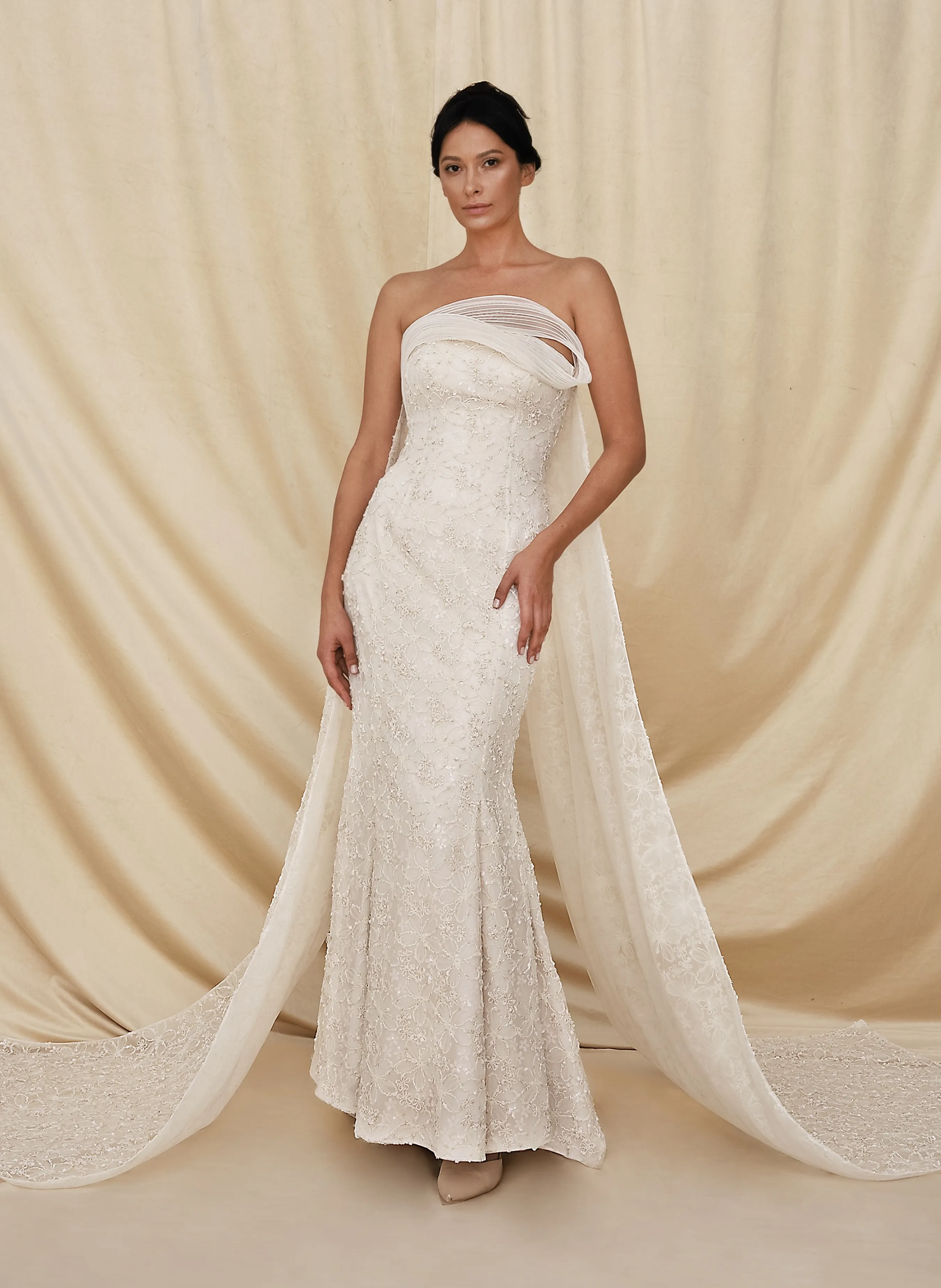 Luxury cream couture evening dress featuring a strapless mermaid silhouette with elegant embroidery and a flowing scarf by Obayh Luxury Fashion.